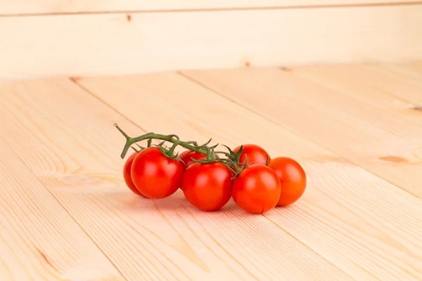 Pomodori ciliegia sul pavimento in legno . — Foto Stock