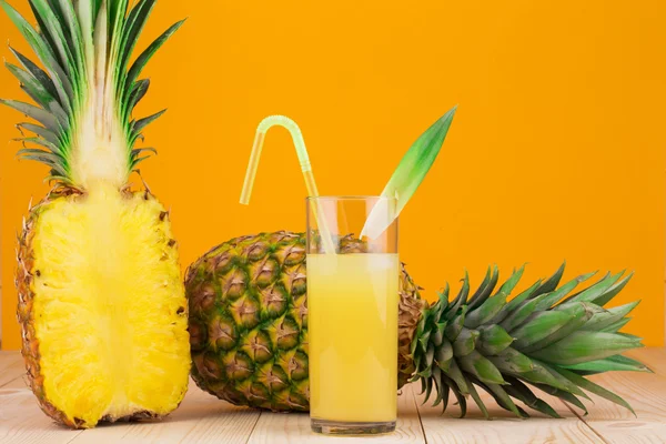 Halvdelen af frisk moden ananas og juice - Stock-foto