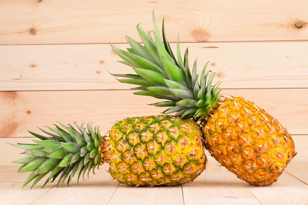 Pineapples on wooden background — Stock Photo, Image