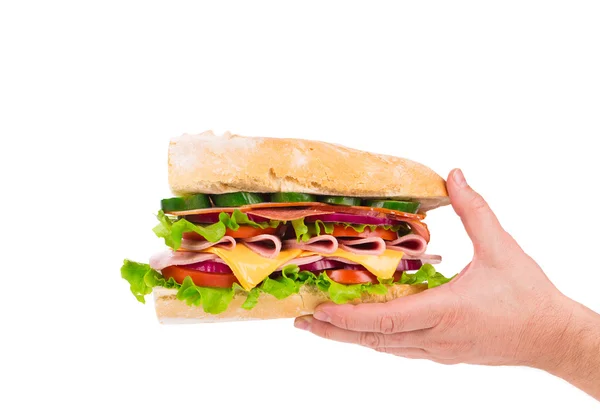 Sandwich mit Speck und Gemüse in der Hand. — Stockfoto