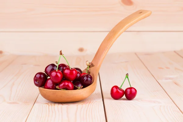 Cereza dulce en una cuchara de madera . — Foto de Stock