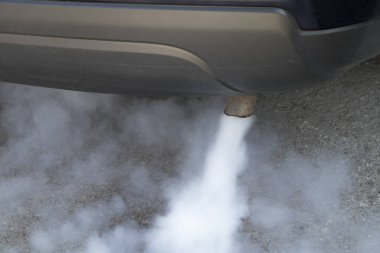 Araba egzoz borusundan çıkan egzoz dumanı. Dünya 'da küresel ısınmaya yol açan hava emisyonları.