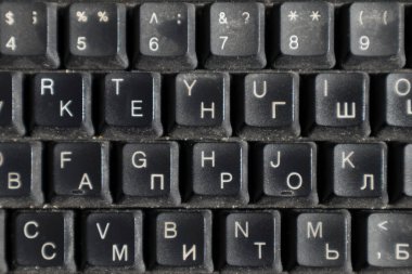 İngilizce ve Rusça alfabesi olan kirli klavye. Yakın plan. Arkaplan olarak kullanılabilir.
