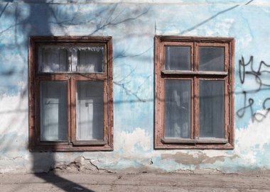 Yıpranmış bir duvardaki iki eski pencere. Yakın plan..