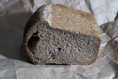 Tam tahıllı undan pişirilmiş ekmek. Fırınlanması için, kolleksiyonlu bir buğday türü olan Spelta ihmaltum kullanıldı. Paket kağıdının üzerinde yer alır. Yakın plan..