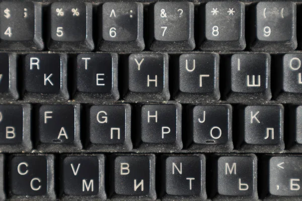 İngilizce ve Rusça alfabesi olan kirli klavye. Yakın plan. Arkaplan olarak kullanılabilir.