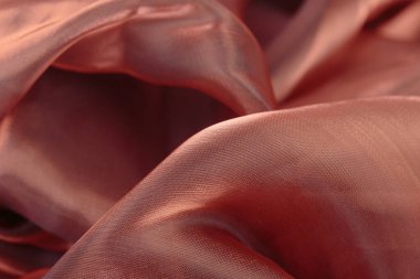 Kumaşın dokusu yakından kahverengidir. Dalgalı kumaştan yapılmış güzel soyut arkaplan.