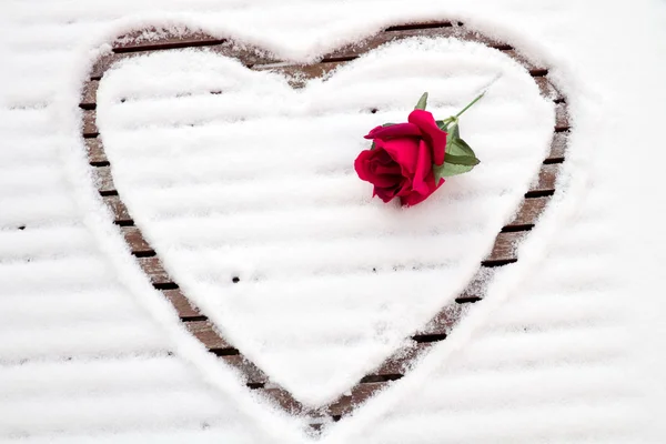 Cuore disegnato nella neve con una rosa — Foto Stock