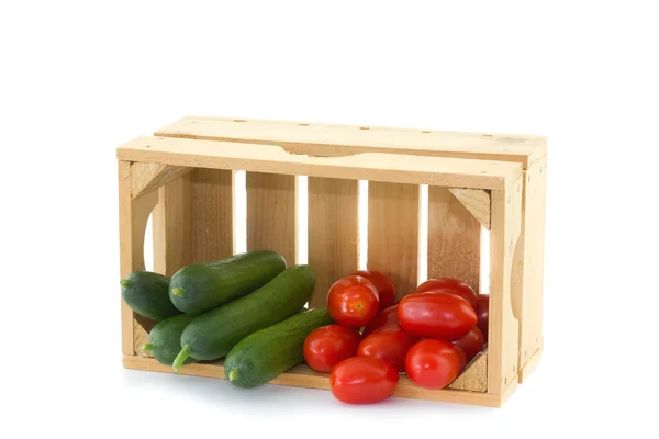 Pepinos y tomates en una caja de madera — Foto de Stock