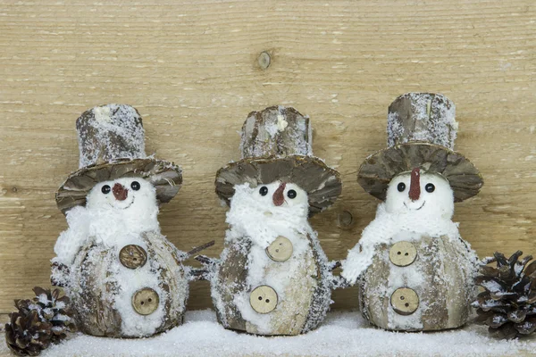 Три снеговика с сосновыми шишками Стоковое Изображение