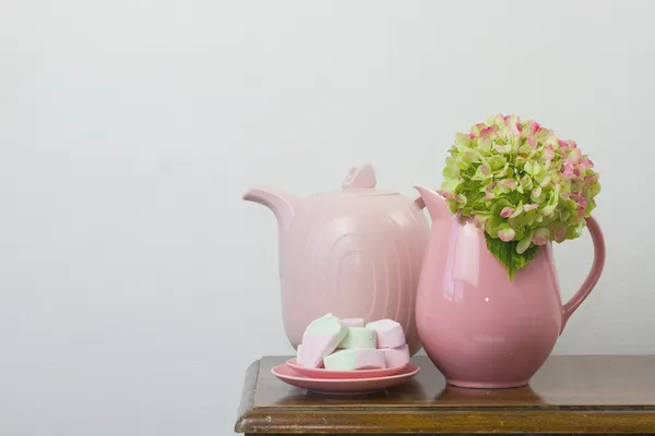 Розовый чайник и зефир — стоковое фото