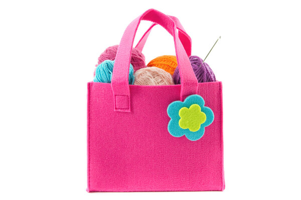 crochet hook and balls of yarn in a felt handbag