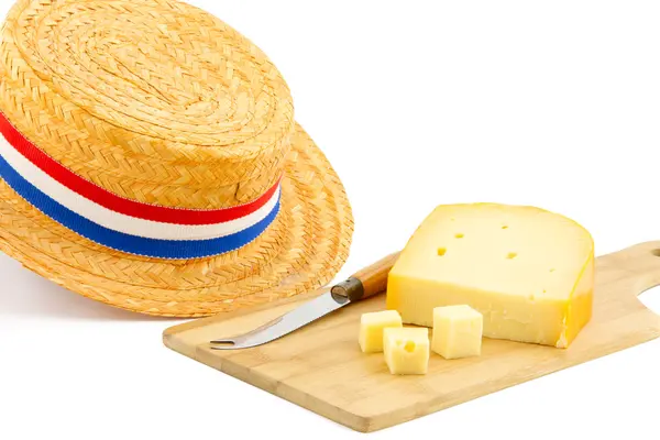 Кусочек сыра на разделочной доске и оранжевая шляпа — стоковое фото