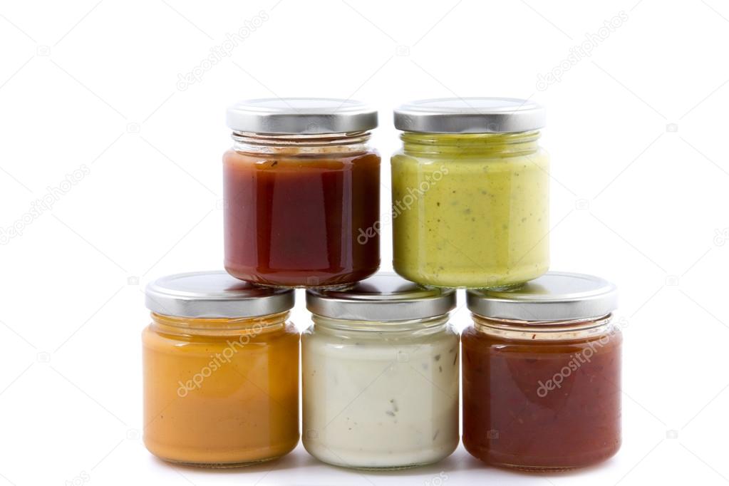 five jars filled with various sauces