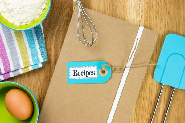 Receptenboek met theedoek, ingrediënten en keukengerei — Stockfoto