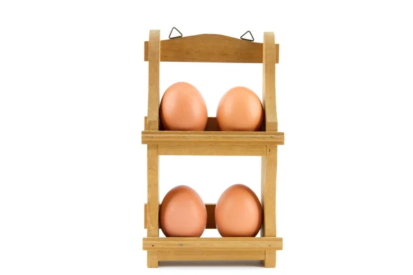 Четыре яйца в деревянной стойке для яиц — стоковое фото