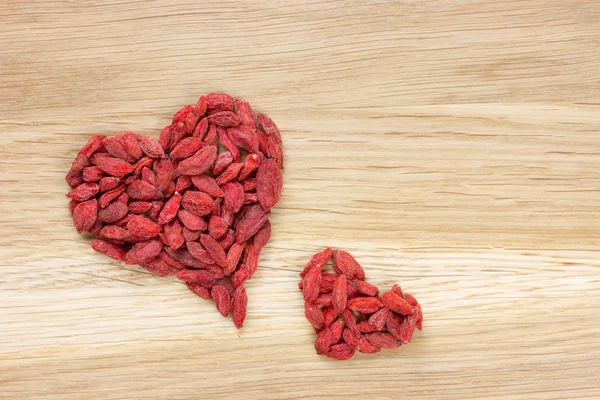 Большое и маленькое сердце, сделанное из ягод годжи — стоковое фото