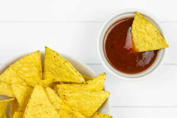 Parte di una ciotola piena di tortilla chips e immersione — Foto Stock