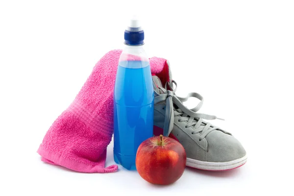 Спортивный инвентарь, такой как кроссовки, энергетические напитки, полотенце и яблоко — стоковое фото