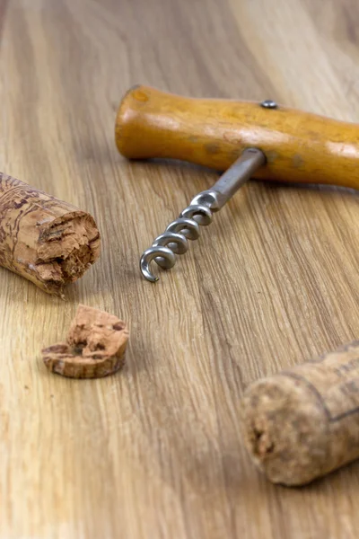 Tire-bouchon avec bouchons sur la surface en bois — Photo