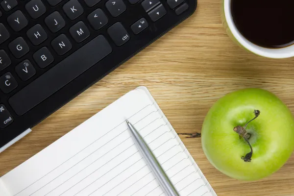 Top-view of keyboard, apple and writing equipment — Stock Photo, Image