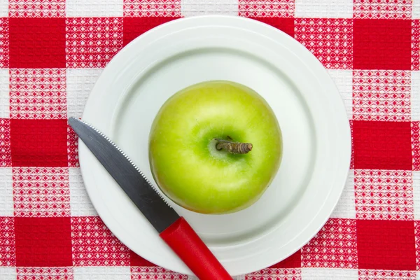 Table cloth with plate and green apple on it — Stock Photo, Image
