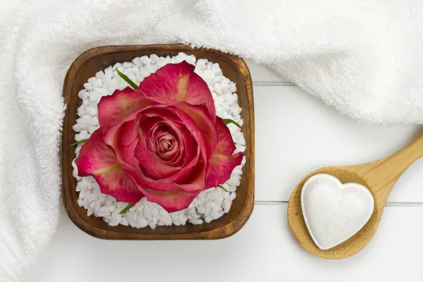 Wooden spoon with heart shaped bath fizzer and bath salt with re — Stock Photo, Image