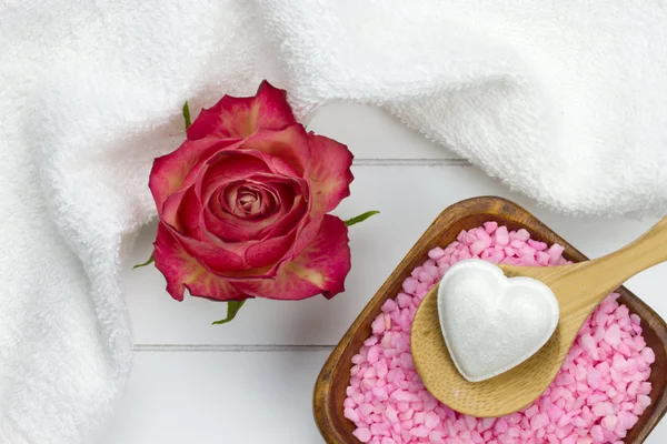 Sal de baño rosa en tazón de madera y fizzer de baño en forma de corazón blanco —  Fotos de Stock