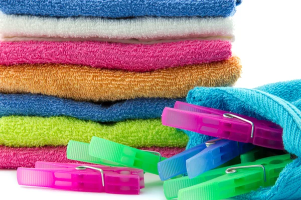 Clothes pegs with pile of towels — Stock Photo, Image