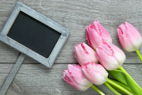 Lemovaný fantazie ozdůbky tulipány na dřevěné pozadí — Stock fotografie