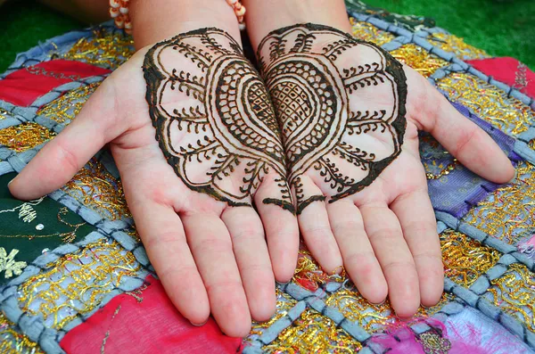 En henna tatuering på en kvinna hand. färgad bakgrund — Stockfoto