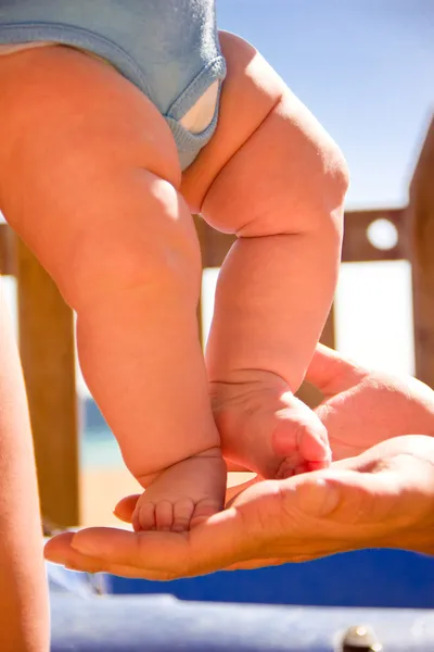 Los pies del bebé en las manos de la madre Fotos de stock