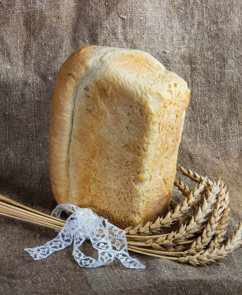Pão e trigo no fundo de saque — Fotografia de Stock