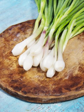 eski püskü ahşap zemin üzerine taze yeşil soğan