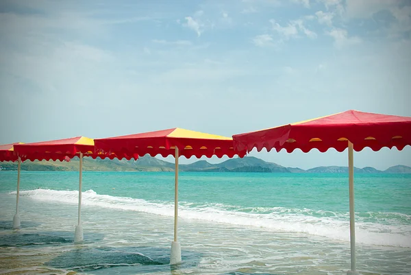 Sombrillas de colores en la playa, estilo retro vintage —  Fotos de Stock