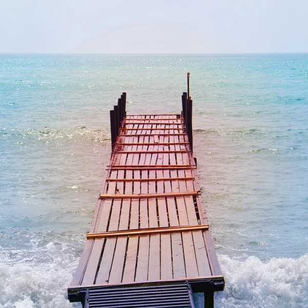 Old wooden bridge in the sea in a retro style — Stock Photo, Image