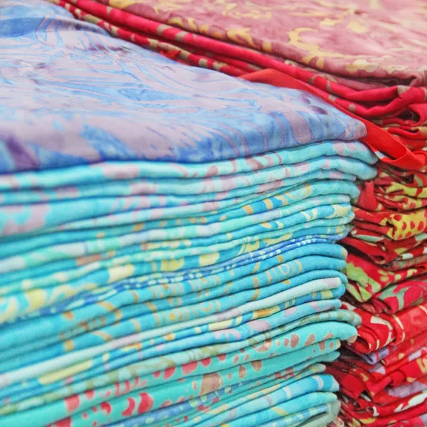 Foulards multicolores sur un comptoir de magasin, pile de tissu coloré — Photo