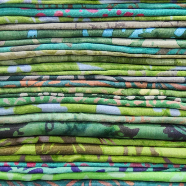 Foulards multicolores sur un comptoir de magasin, pile de tissu coloré — Photo