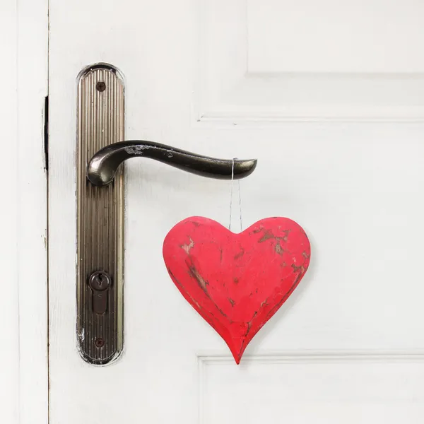 Corazón rojo colgando de la manija de la puerta — Foto de Stock