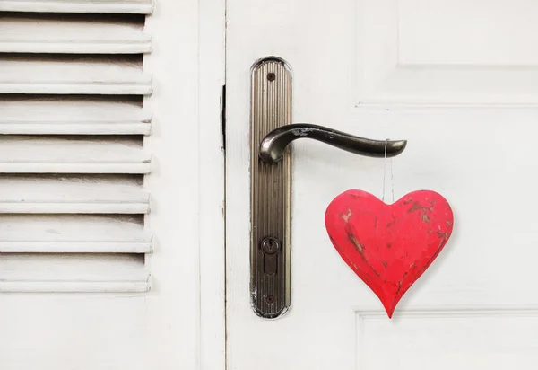 Vintage red heart hanging on the door handle — Stock Photo, Image