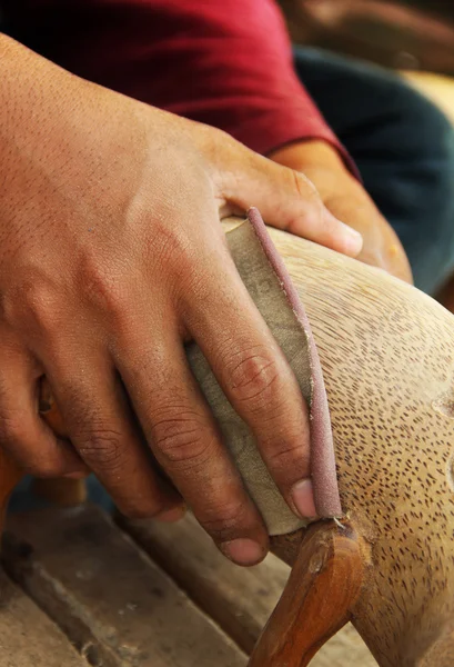 Mann poliert Holzskulptur aus Sandpapier — Stockfoto
