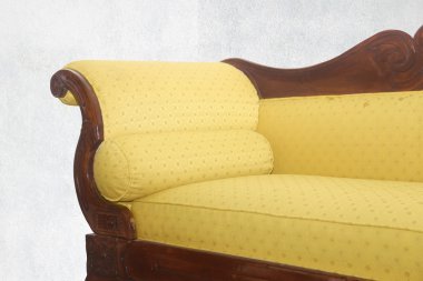 gri bir arka plan üzerinde eski bir kanepe ve detay