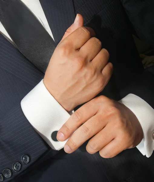A man in a black suit straightens his  cufflinks — Stock Photo, Image