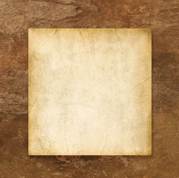 Старая чистая бумага на коричневом выветриваемом деревянном фоне — стоковое фото