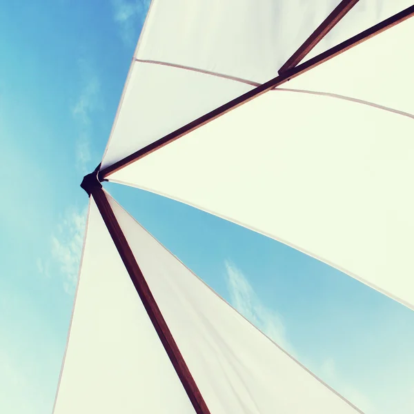 Guarda-chuva de praia ou vela em um iate com céu azul. efeito vintage — Fotografia de Stock