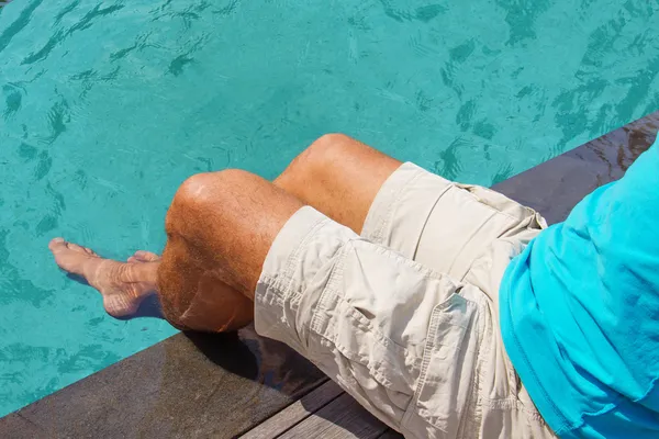 Men's feet in the turquoise water — Stock Photo, Image