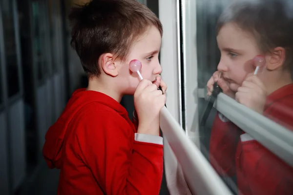 Child with dreamy eyes facing out the window of a train. — Stock Photo, Image