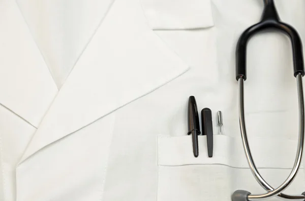 Doctor scrubs with stethoscope, thermometer and pens in the pock — Stock Photo, Image