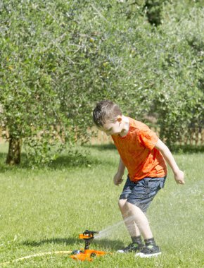 Su Bahçe ile oynayan mutlu çocuk.