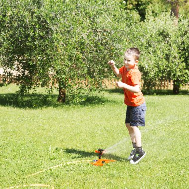 Su Bahçe ile oynayan mutlu çocuk.